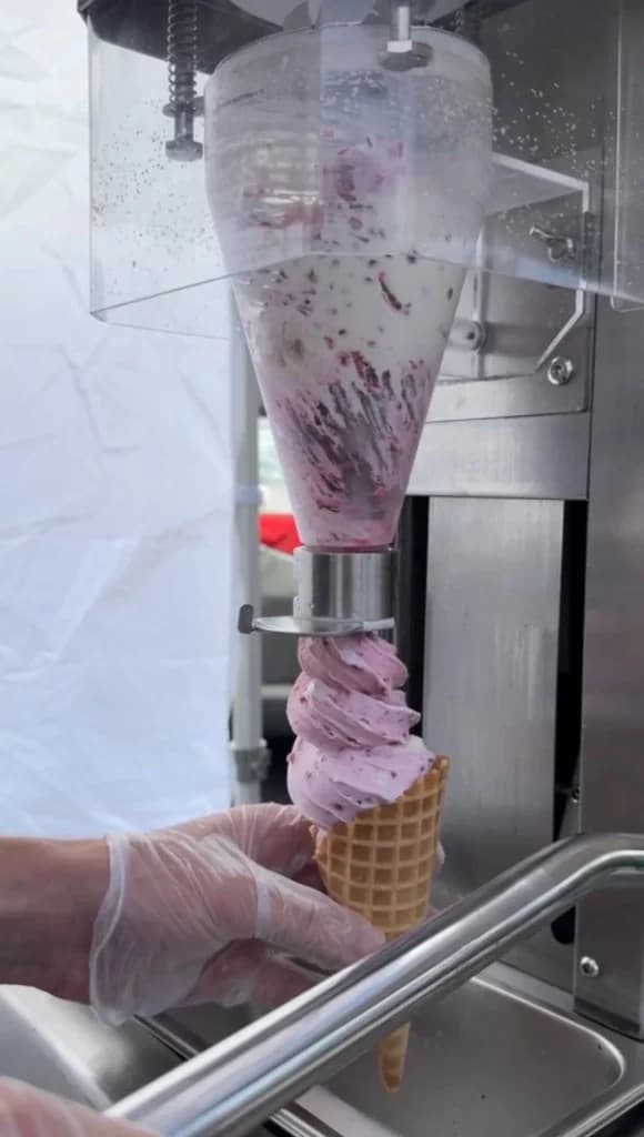 Real fruit soft-serve being dispensed into a waffle cone